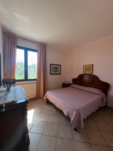 une chambre avec un grand lit et une fenêtre dans l'établissement Podere Quercia al Santo, à Lajatico