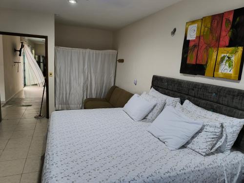 a bedroom with a bed with pillows and a couch at Dalia in Cedro