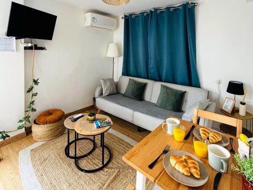 - un salon avec un canapé et une table avec du pain dans l'établissement Appartement climatisé avec terrasse - Goupama Stadium, Eurexpo, LDLC Arena, La Soie, à Vaulx-en-Velin