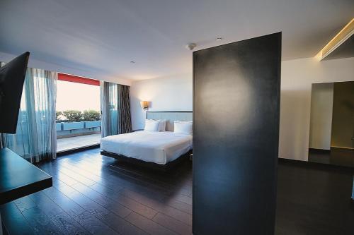 a hotel room with a bed and a large window at Hilton DoubleTree Guadalajara Centro Historico in Guadalajara