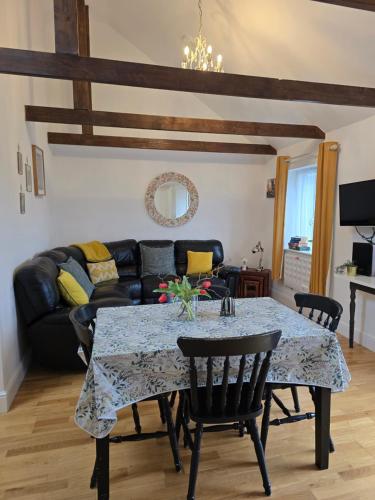a living room with a table and a couch at Willow Cottage in idyllic location in Kent