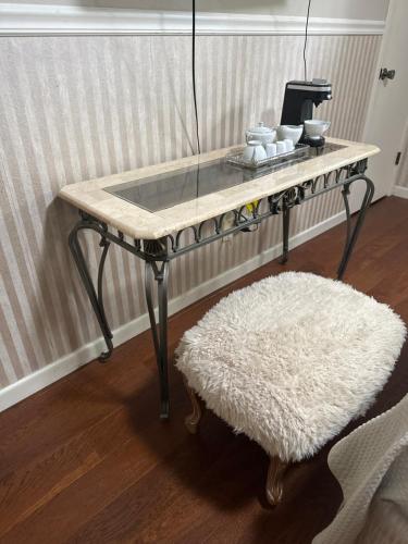 a coffee table with a white rug and a stool at Nice and peaceful bedroom in Wake Village