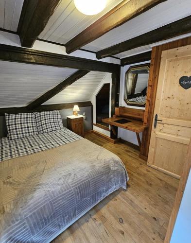 une chambre avec un lit et un parquet dans l'établissement Domaine du Petit Dorsbach, à Soultzbach-les-Bains