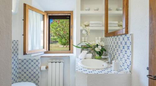 Un baño con lavabo y ventana. en Tenuta Bonelli, en Castelnuovo Berardenga