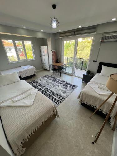 a bedroom with two beds and a table and windows at Panorama house in Denizli