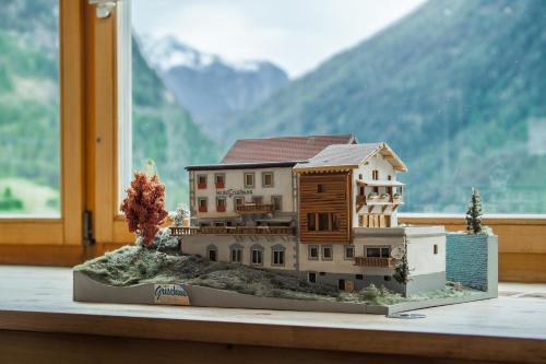 a model of a house in front of a window at Hotel Grischuna Filisur in Filisur