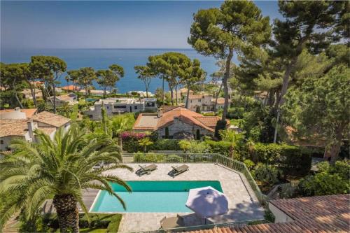 un complexe avec une piscine et une vue sur l'océan dans l'établissement Sublime villa with sea view in Cap d'Antibes, 500 m from the beach, à Antibes