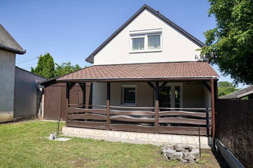 a house with a wooden fence in the yard at Panda Apartman in Hajdúszoboszló