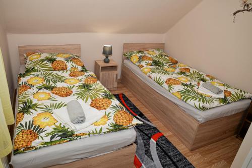 two beds in a room with pineapples at Panda Apartman in Hajdúszoboszló