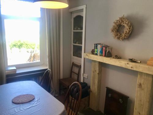 a dining room with a table and a window at Simple Welsh Terrace with Valley Views in Morriston