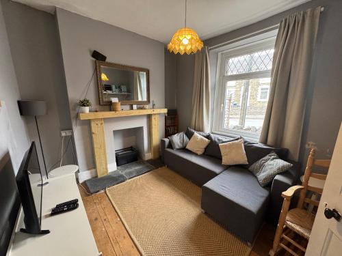 a living room with a couch and a fireplace at Simple Welsh Terrace with Valley Views in Morriston