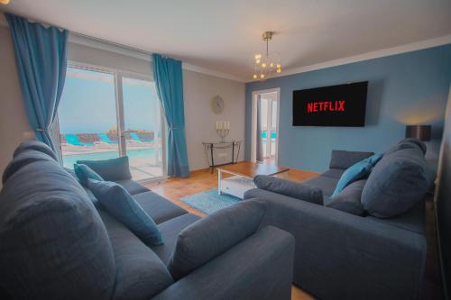 a living room with a couch and a tv at Casa Conil with a private 25 meter heated pool in Conil