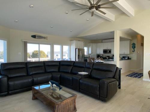 a living room with a black leather couch and a table at Lagoon Front, Loveladies, Dock, Decks, Beach Badges, Bikes, Ping Pong Table, Foosball, Wifi,gorgeous Reverse-Living Loveladies Contemporary On A, in Loveladies