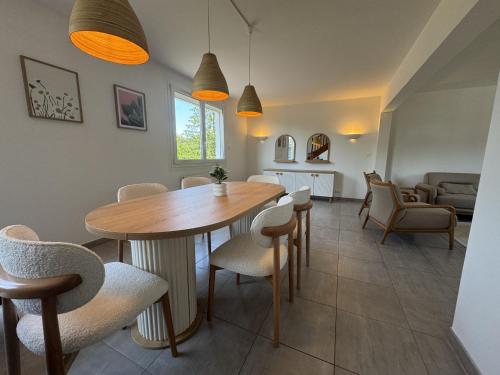 une salle à manger et un salon avec une table et des chaises dans l'établissement La Porte du Circuit - 8pers - Confort - Rêve au Mans, à Ruaudin