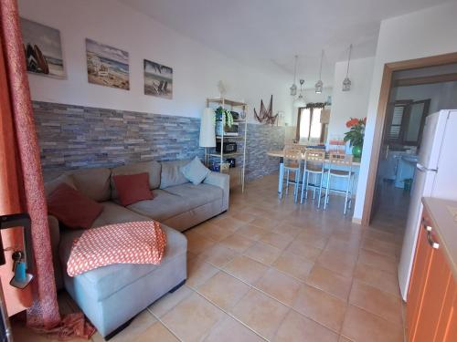 salon z kanapą i kuchnią w obiekcie Appartamento residence Tartaruga 3 w mieście Castelsardo