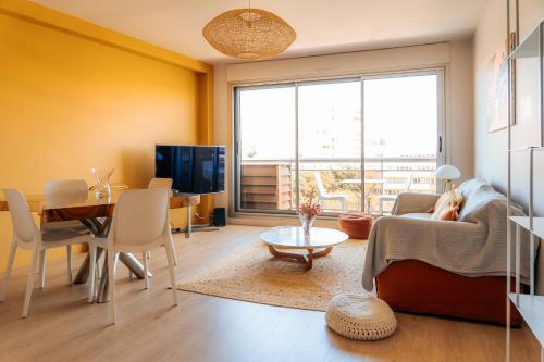 - un salon avec une personne assise sur un canapé dans l'établissement Ô Bellevue -T3 Standing - Centre ville - Climatisation, à Toulouse