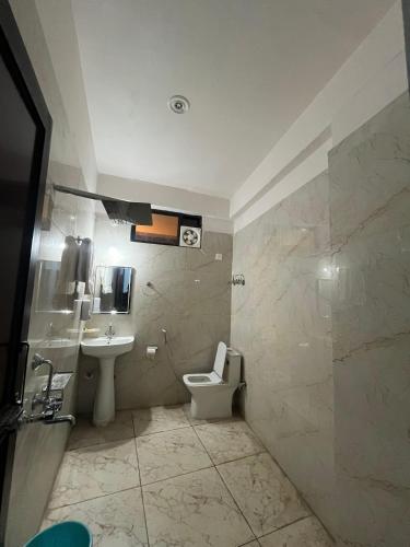 a bathroom with a toilet and a sink at Mayank Palace in Almora