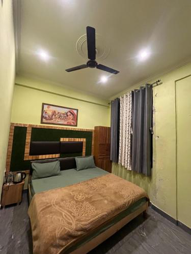 a bedroom with a bed and a ceiling fan at Mayank Palace in Almora