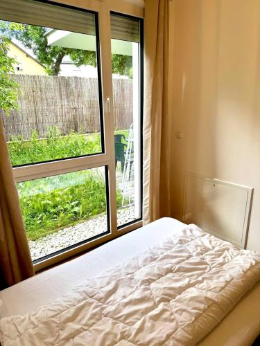 une chambre avec un lit et une grande fenêtre dans l'établissement Cozy 2BR Apartment In Floridsdorf Area, à Vienne
