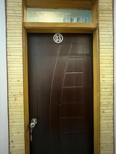 a brown door with a number on it at Mayank Palace in Almora