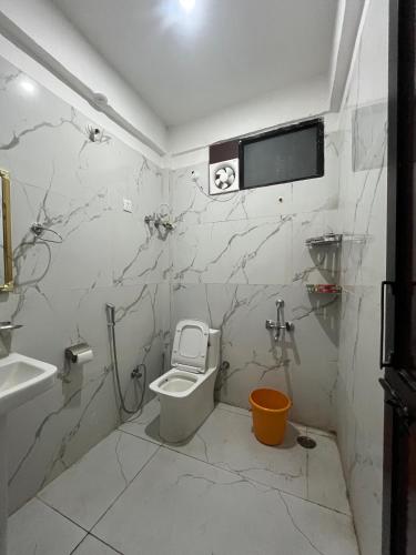 a bathroom with a toilet and a sink at Mayank Palace in Almora