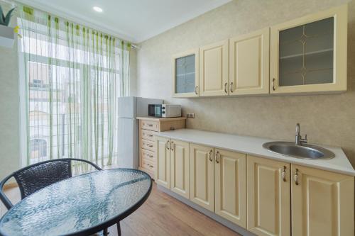 a kitchen with a sink and a table and a window at Apartment on Sumskaya 46 "Central Residence" in Kharkiv