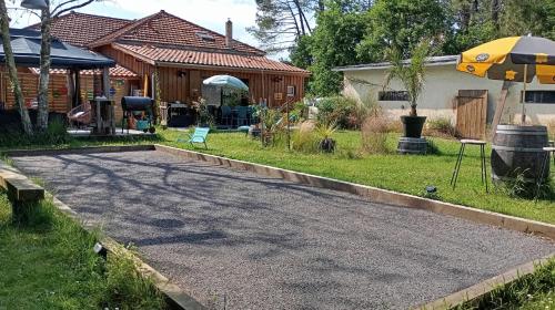 une allée devant une maison avec un parapluie dans l'établissement Entre Bassin et lacs, à Gujan-Mestras