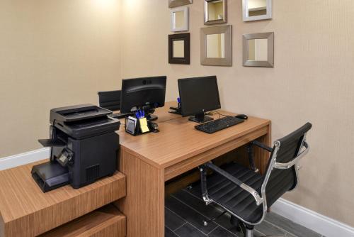 an office with a desk with two monitors and a printer at Holiday Inn Express Hotel & Suites Bonita Springs/Naples by IHG in Bonita Springs