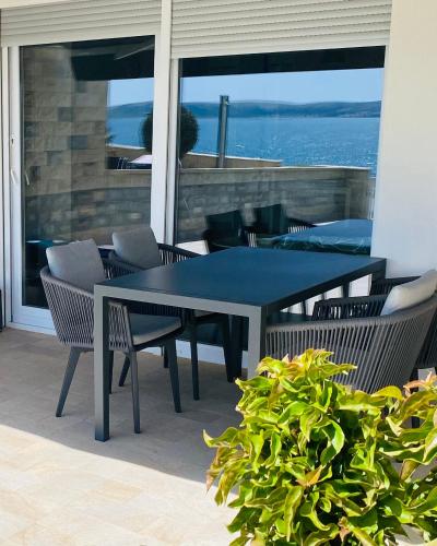 a blue table and chairs on a patio with the ocean at Beachfront deluxe apartment in Povljana