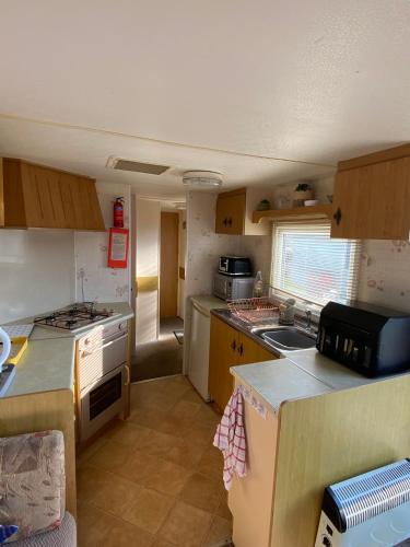 a small kitchen with a sink and a stove at i13 the chase caravan park in Ingoldmells