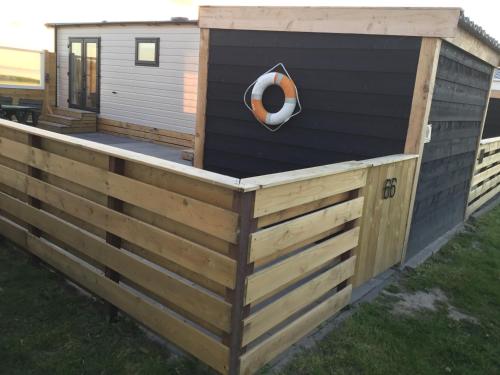 a backyard chicken coop with a dog door at Prachtig chalet de ZEE STER in Westerland
