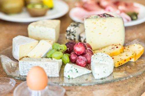 a plate of cheese and grapes and eggs on a table at Garni Weghueb in Rablà
