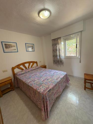 a bedroom with a bed and a window at APCOSTAS - Complejo Al Andalus in Alcossebre