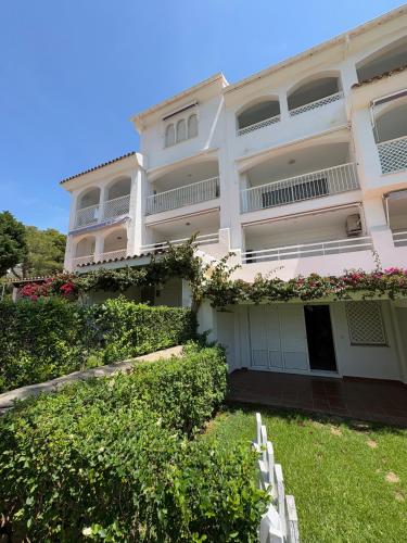 a white building with a yard in front of it at APCOSTAS - Complejo Al Andalus in Alcossebre