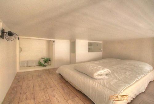 une chambre avec un lit blanc dans une pièce dans l'établissement Joli studio proche mer, à Vallauris