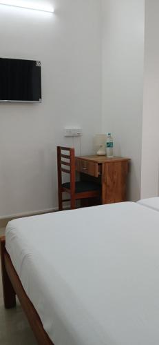 a bedroom with a desk and a bed and a table at annies inn homestay in Cochin