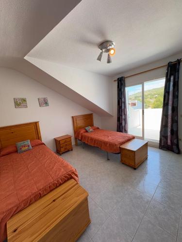 a bedroom with two beds and a window at APCOSTAS - Complejo Al Andalus in Alcossebre