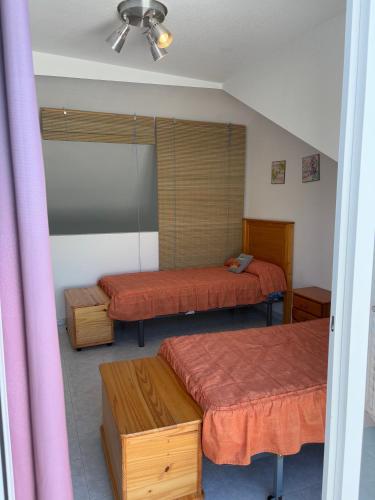 two beds in a room with pink curtains at APCOSTAS - Complejo Al Andalus in Alcossebre