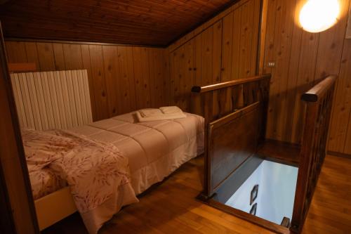 a bedroom with a bed in a wooden room at Casa Orfea in Stresa