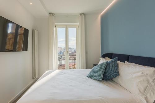 a bedroom with a white bed with a window at QI in Centro, Elegant Guesthouse in Sassari