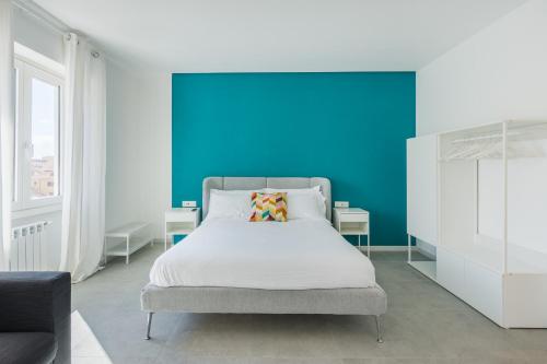 a bedroom with a bed with a blue wall at QI in Centro, Elegant Guesthouse in Sassari