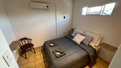 sypialnia z łóżkiem, krzesłem i oknem w obiekcie Confortable Apartamento Excelente Ubicación w mieście Bañado Sur