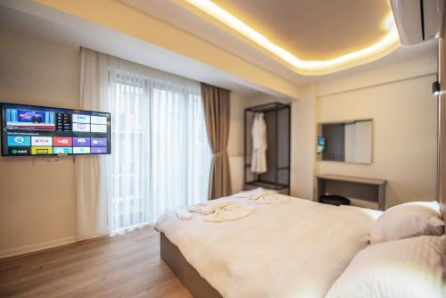 a hotel room with a bed and a flat screen tv at Mar Residence in Istanbul