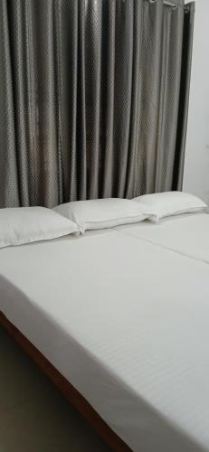a close up of a bed in front of a curtain at annies inn homestay in Cochin