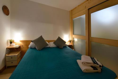 a bedroom with a blue bed with a window at Petit Bijou Morgex in Morgex