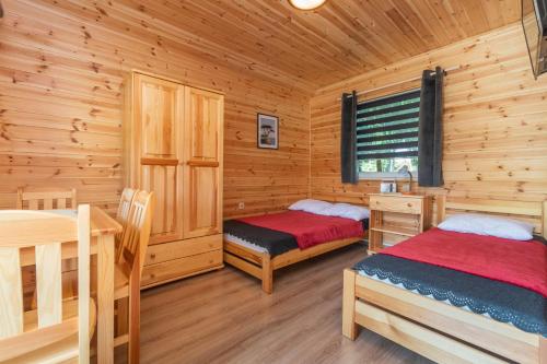 a bedroom with two beds in a log cabin at Domek 4 osobowy in Stegna
