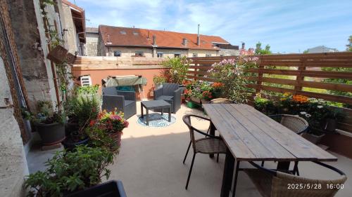 a patio with a wooden table and chairs and plants at Les Bonbonieres d'Andrea Gavinies Pellegrin in Bordeaux