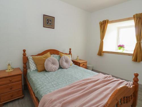 une chambre avec un lit avec des oreillers et une fenêtre dans l'établissement Bathach Mor, à Oban