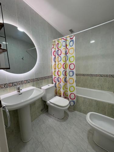 a bathroom with a sink and a toilet and a mirror at APCOSTAS - Complejo Al Andalus in Alcossebre