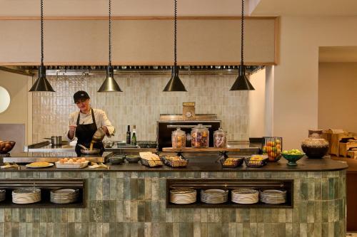 a chef preparing food in a large kitchen at Kimpton Los Monteros Marbella by IHG in Marbella
